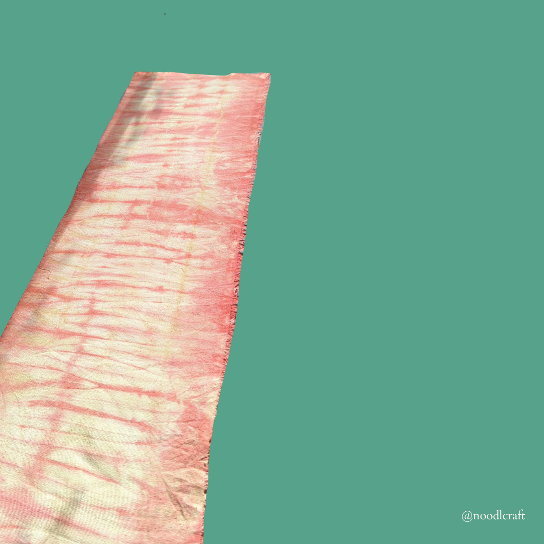 Drying pink-yellow fabric, stretched out.