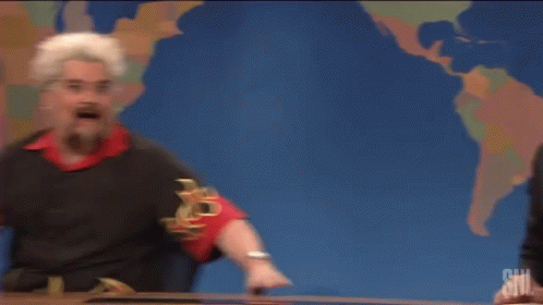 An actor pretending to be Guy Fieri sliding into view at the Weekend Update desk