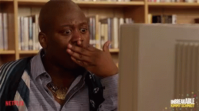 Tituss Burgess looking at a computer and gasping in shock